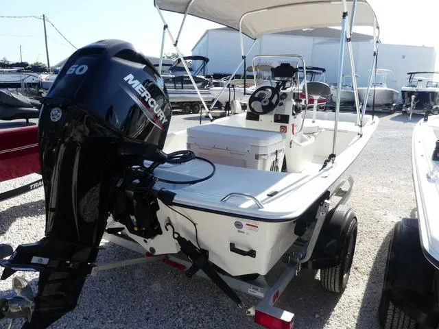 Slide: The Image of 2024 Mako Pro Skiff 15 CC boat with Mercury engine, parked on a trailer. - 6