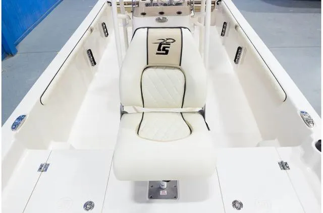Slide: The Image of 2021 Carolina Skiff 21LS boat interior with white seating and logo. - 14