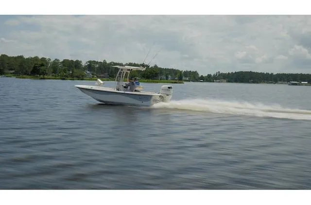 Slide: The Image of 2021 Carolina Skiff 21LS boat cruising on a calm lake under a cloudy sky. - 3