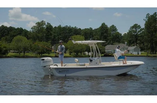 Slide: The Image of 2021 Carolina Skiff 21LS boat with two people fishing on a calm lake. - 5