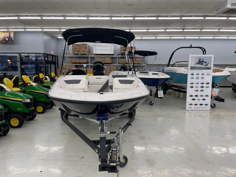 Slide: The Image of 2025 Bayliner Element E16 boat displayed in showroom with canopy and trailer. - 6