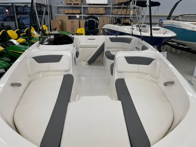Slide: The Image of 2025 Bayliner Element E16 boat interior with gray and white seating in showroom. - 7