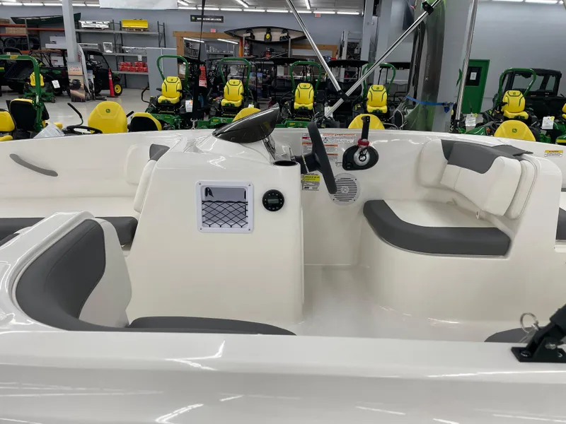 Slide: The Image of 2025 Bayliner Element E16 boat interior with gray seating, displayed in a showroom. - 9