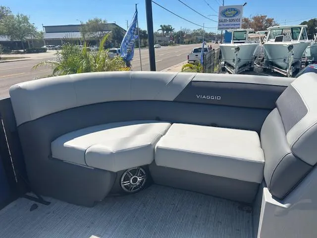 Slide: The Image of 2024 Viaggio V 20 U boat with gray seating and speaker, parked near a sales service area. - 8