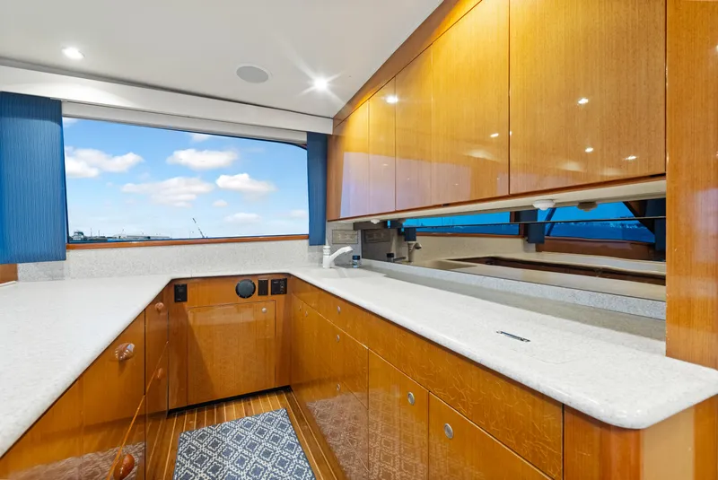 Slide: The Image of Luxurious kitchen interior of a 2001 Viking Convertible yacht with wooden cabinets and ocean view. - 24