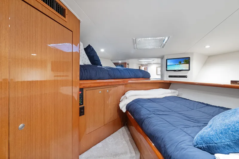 Slide: The Image of 2001 Viking Convertible yacht cabin with wooden interior, twin beds, and wall-mounted TV. - 29