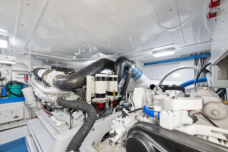 Slide: The Image of Engine room of a 2001 Viking Convertible yacht, showcasing complex machinery and piping. - 36