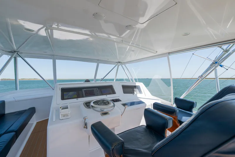 Slide: The Image of 2001 Viking Convertible yacht helm with ocean view, featuring leather seating and modern controls. - 4
