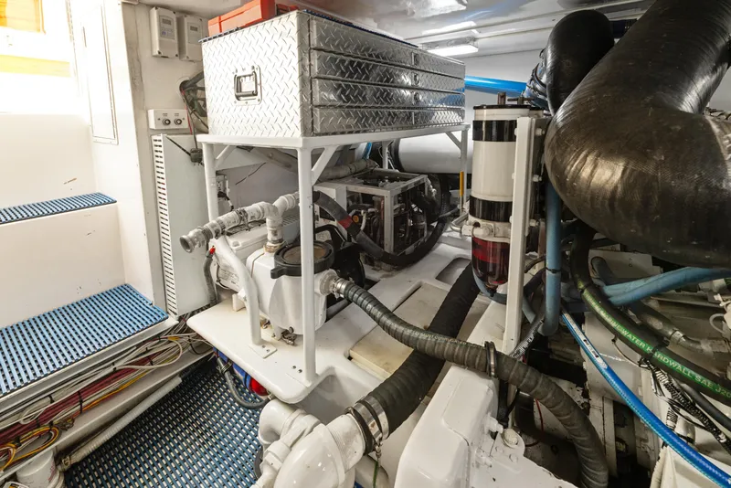 Slide: The Image of Engine room of a 2001 Viking Convertible yacht, featuring mechanical components and storage. - 42