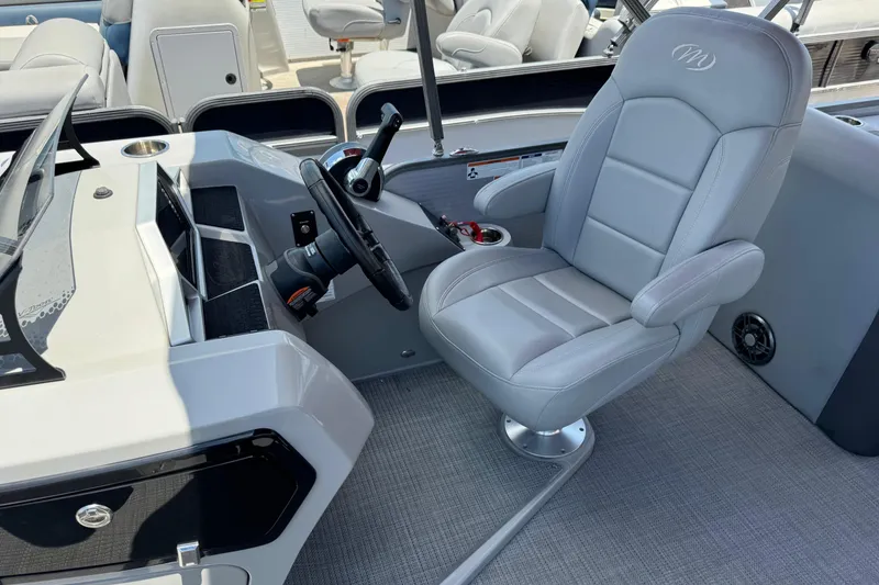 Slide: The Image of 2022 Manitou Oasis SR VP boat interior with gray captain's chair and steering console. - 10