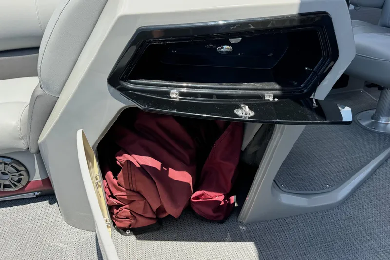 Slide: The Image of 2022 Manitou Oasis SR VP boat storage compartments with red fabric inside. - 11
