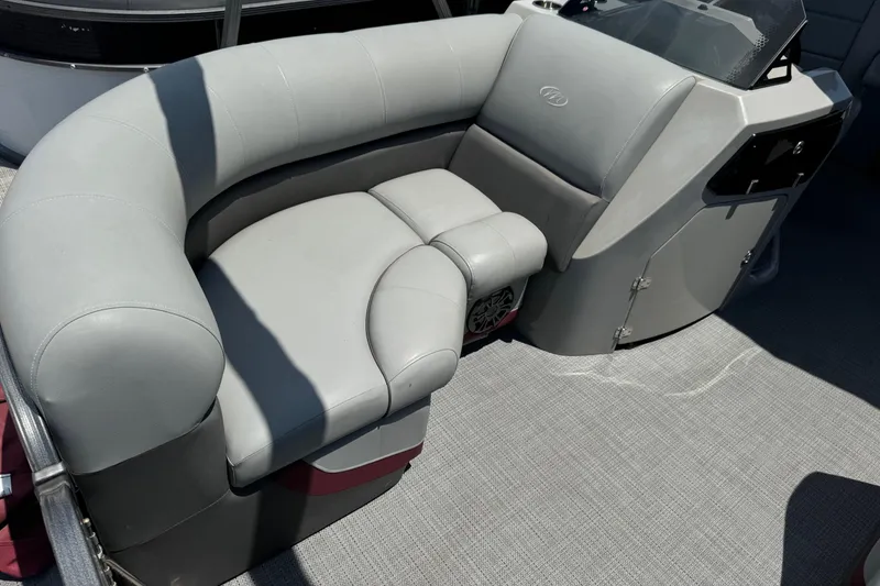 Slide: The Image of 2022 Manitou Oasis SR VP boat with gray cushioned seating and modern design. - 14