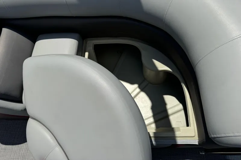 Slide: The Image of 2022 Manitou Oasis SR VP boat seat storage compartment with gray upholstery. - 16