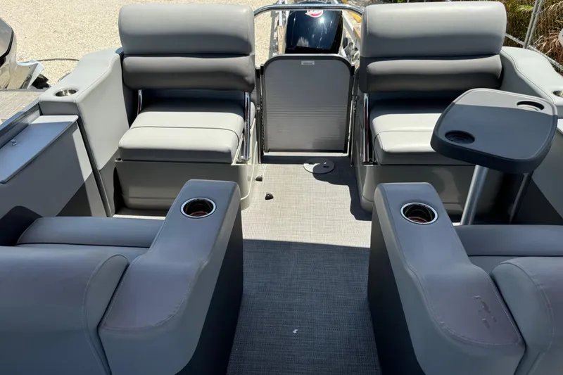 Slide: The Image of 2022 Manitou Oasis SR VP pontoon boat interior with gray seating and cup holders. - 2