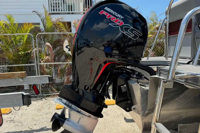 Slide: The Image of 2022 Manitou Oasis SR VP with Mercury Pro XS outboard motor, parked outdoors. - 21