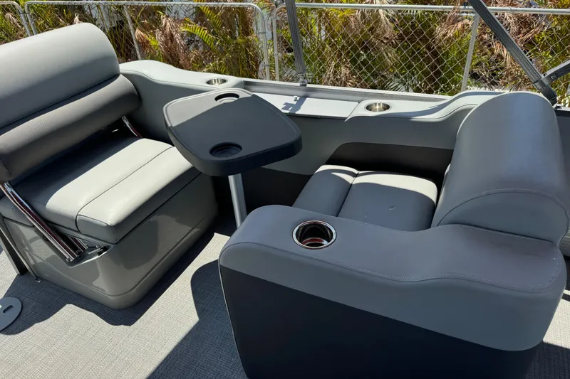 Slide: The Image of 2022 Manitou Oasis SR VP boat interior with gray seating and table. - 6