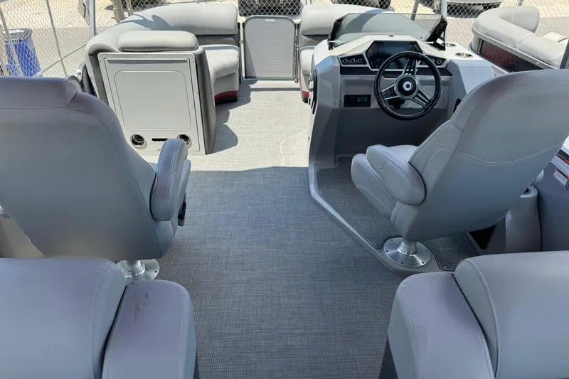 Slide: The Image of 2022 Manitou Oasis SR VP pontoon boat interior with gray seating and steering console. - 7
