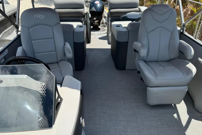 Slide: The Image of 2022 Manitou Oasis SR VP pontoon boat interior with gray seating and steering console. - 8