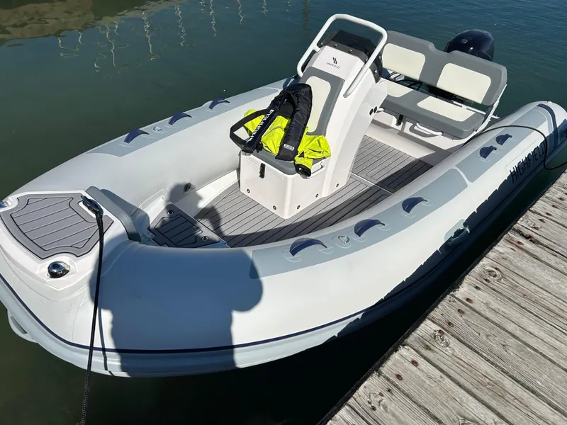 Slide: The Image of 2024 Highfield Classic 420 boat docked, featuring a sleek design and modern seating. - 0