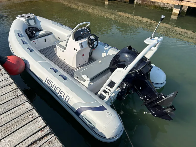 Slide: The Image of 2024 Highfield Classic 420 inflatable boat docked on calm water. - 1