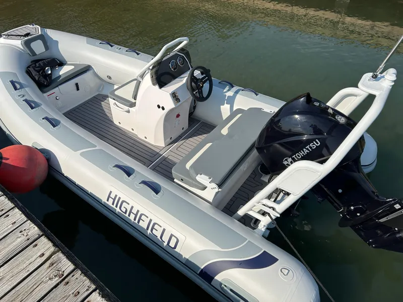 Slide: The Image of 2024 Highfield Classic 420 boat with Tohatsu engine docked on water. - 13