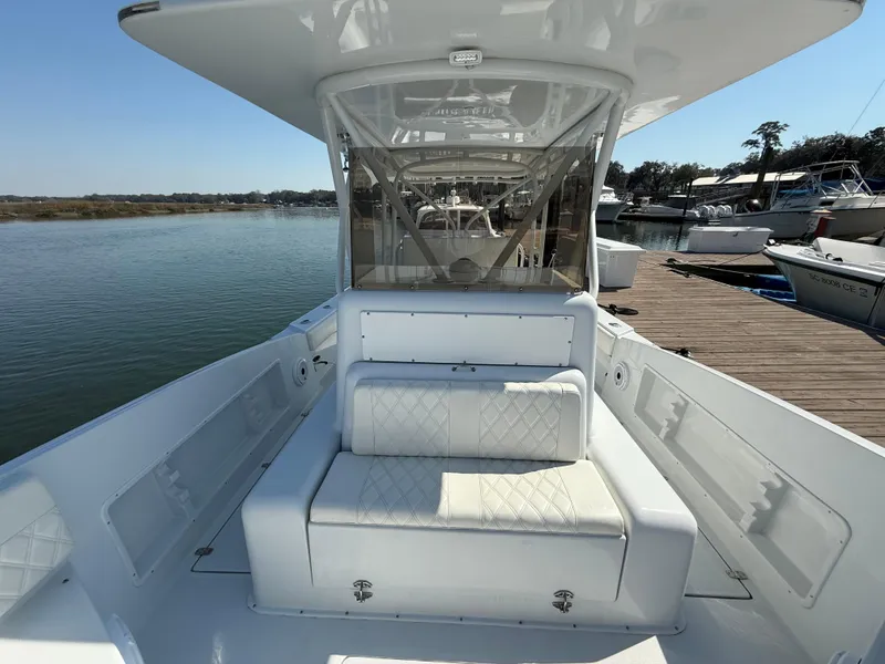 Slide: The Image of 2003 Strike 35 Cuddy boat with white seating, docked by the water. - 12