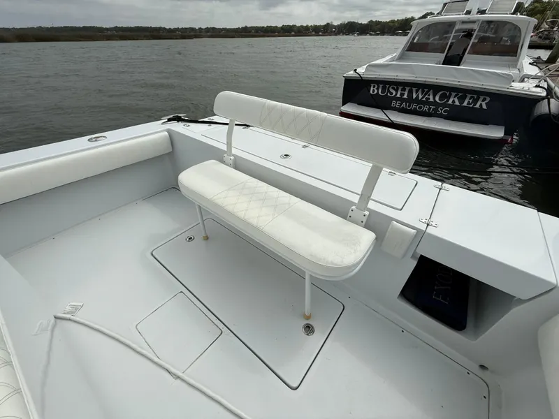 Slide: The Image of 2003 Strike 35 Cuddy boat with white seating, docked near another vessel. - 15