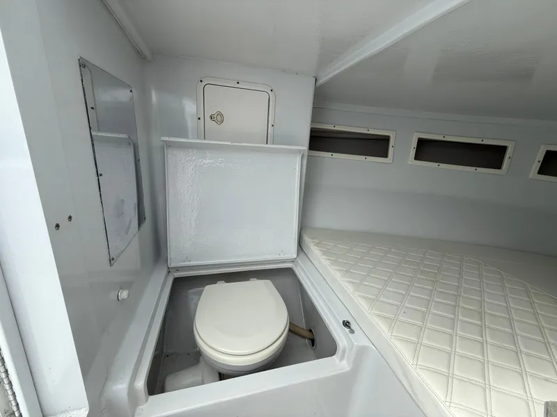 Slide: The Image of 2003 Strike 35 Cuddy boat interior with toilet and cushioned bed. - 19