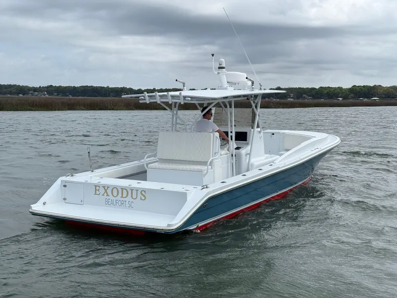 Slide: The Image of 2003 Strike 35 Cuddy boat cruising on water, overcast sky, rear view. - 2