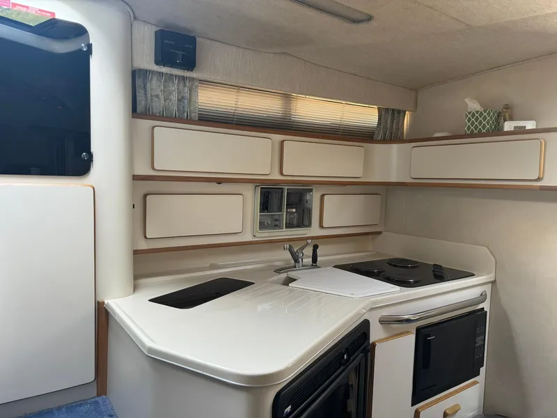 Slide: The Image of 1993 Sea Ray 370 Sundancer yacht kitchen with stove, sink, and cabinets. - 10