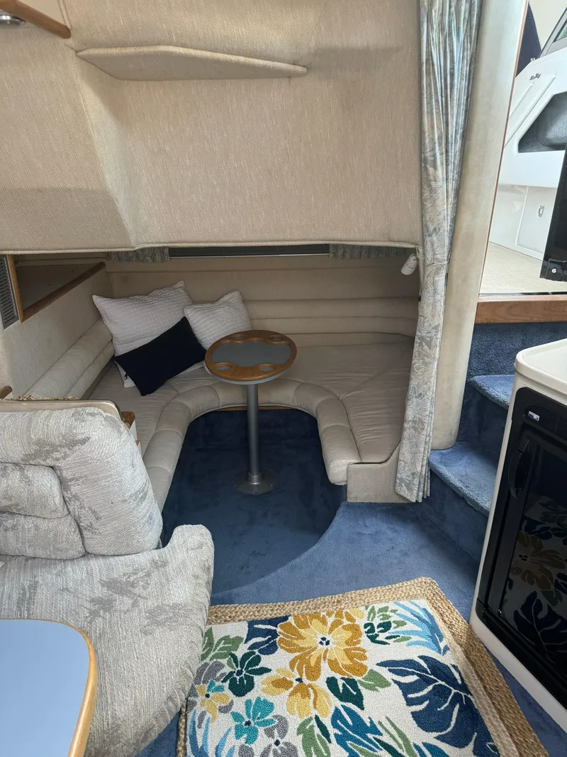 Slide: The Image of Interior of 1993 Sea Ray 370 Sundancer with cozy seating and floral rug. - 14