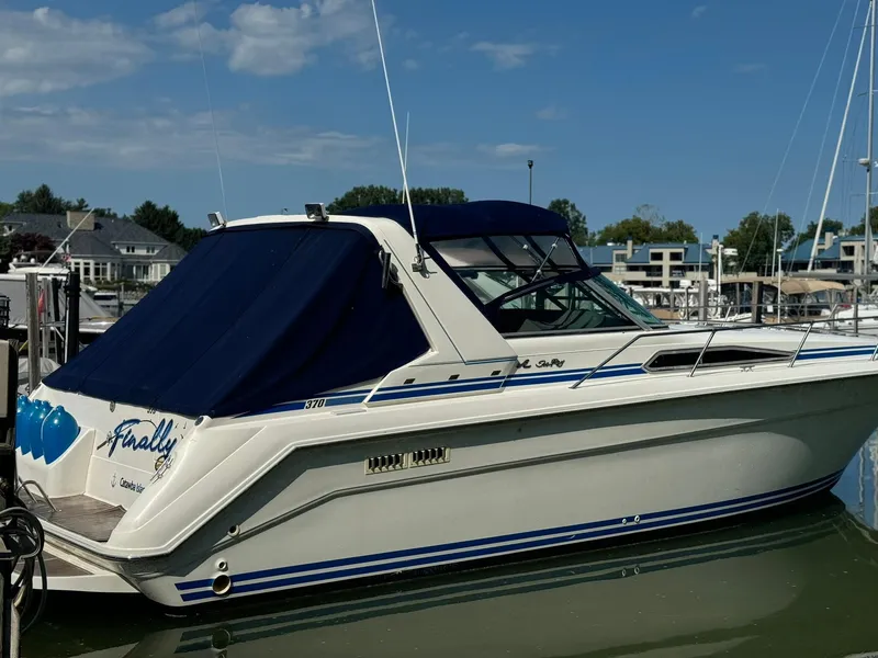 Slide: The Image of 1993 Sea Ray 370 Sundancer boat docked at marina, blue canopy, calm water, clear sky. - 3
