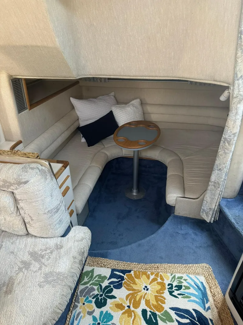 Slide: The Image of Interior of 1993 Sea Ray 370 Sundancer with cozy seating and floral rug. - 8