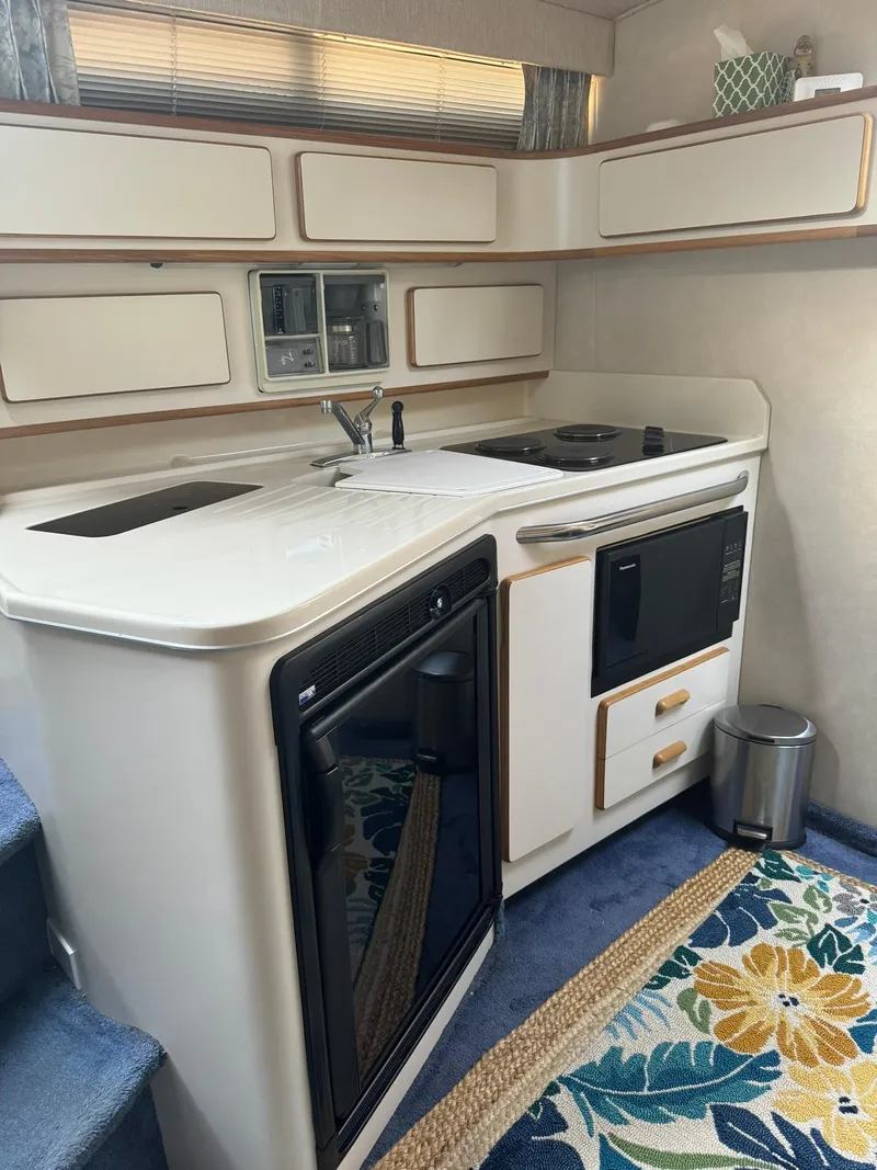 Slide: The Image of 1993 Sea Ray 370 Sundancer kitchen with modern appliances and floral rug. - 9