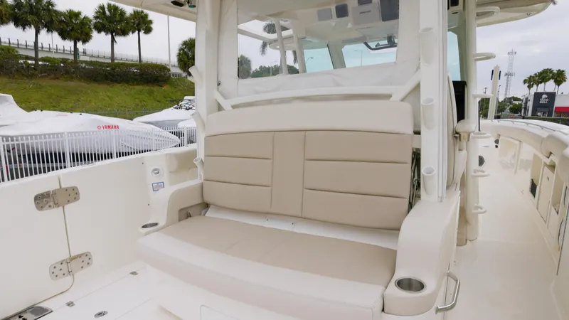Slide: The Image of 2018 Boston Whaler 380 Outrage boat interior with beige seating and cup holders. - 11