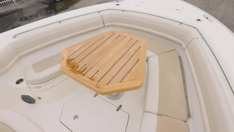 Slide: The Image of 2018 Boston Whaler 380 Outrage boat interior with wooden table and cushioned seating. - 16