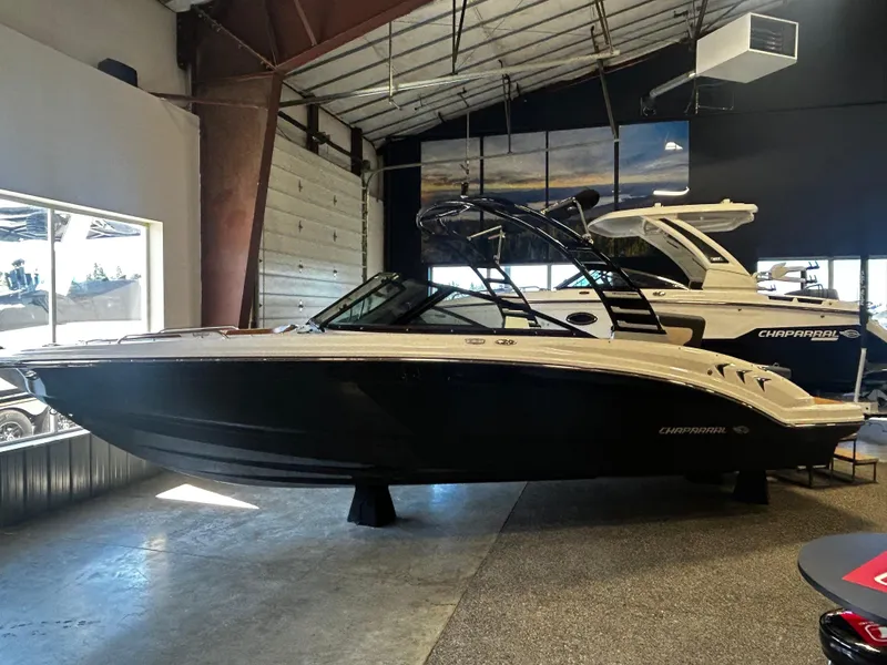 Slide: The Image of 2025 Chaparral 23 SSi boat displayed in a showroom, side view. - 1