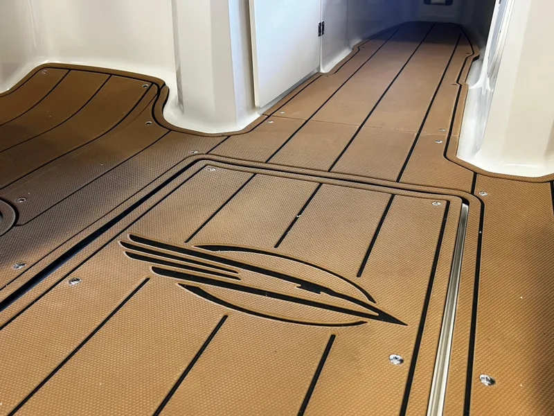 Slide: The Image of 2025 Chaparral 23 SSi boat interior with sleek, brown flooring and stylish design. - 9