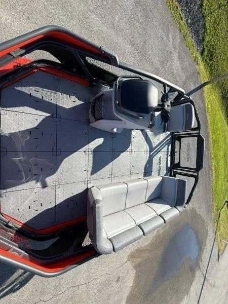 Slide: The Image of 2024 Sea-Doo SWITCH COMPACT 130HP interior with seating and steering console, parked on pavement. - 10