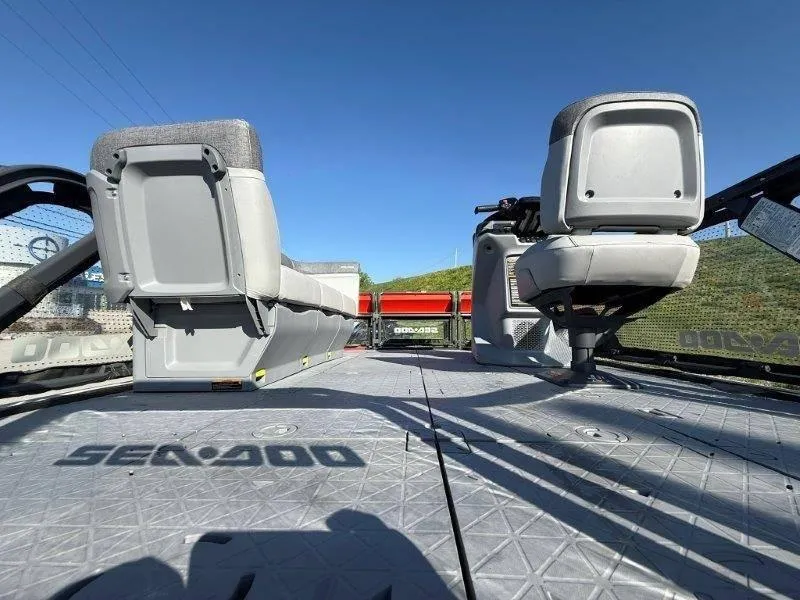 Slide: The Image of 2024 Sea-Doo SWITCH COMPACT 130HP interior with seating and steering, under clear blue sky. - 19
