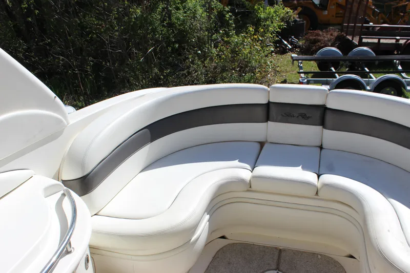 Slide: The Image of 2005 Sea Ray 290 Sundeck interior with white cushioned seating. - 11