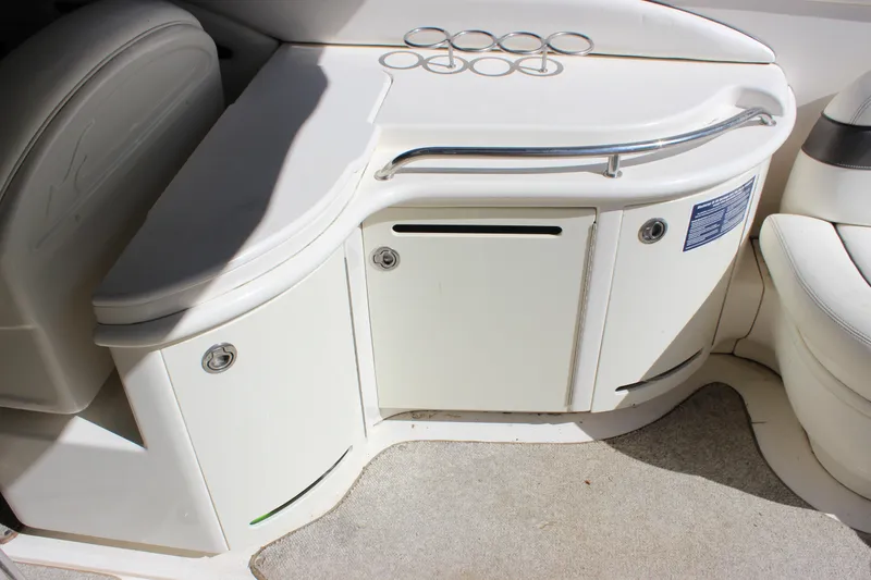 Slide: The Image of 2005 Sea Ray 290 Sundeck interior with storage compartments and cup holders. - 13