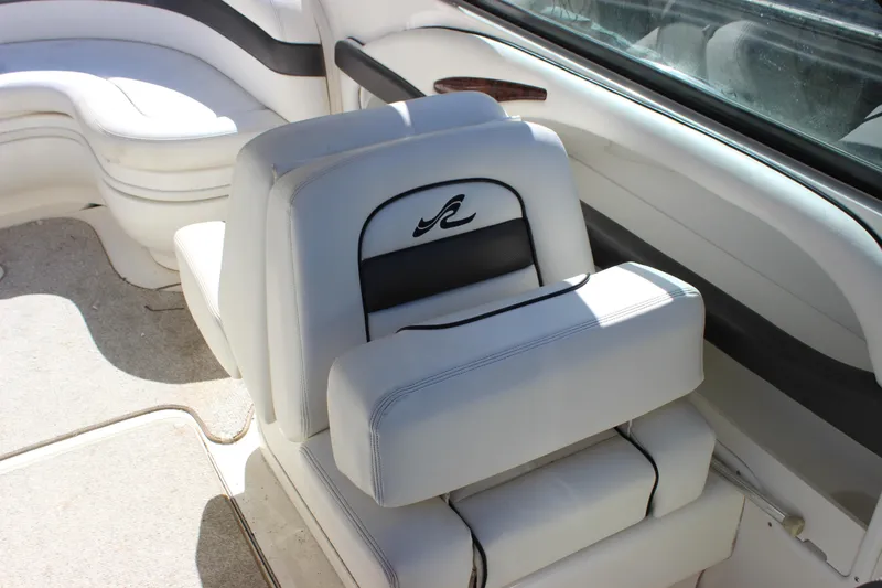 Slide: The Image of 2005 Sea Ray 290 Sundeck interior with white cushioned seating. - 24