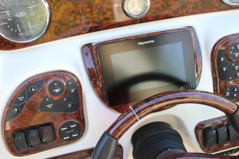 Slide: The Image of Dashboard of 2005 Sea Ray 290 Sundeck with Raymarine display and wood accents. - 25