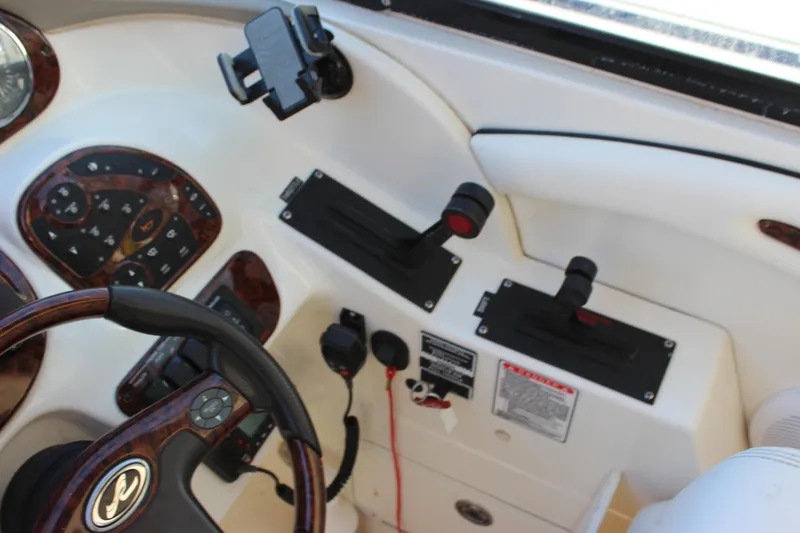 Slide: The Image of 2005 Sea Ray 290 Sundeck helm with steering wheel and control panel. - 26
