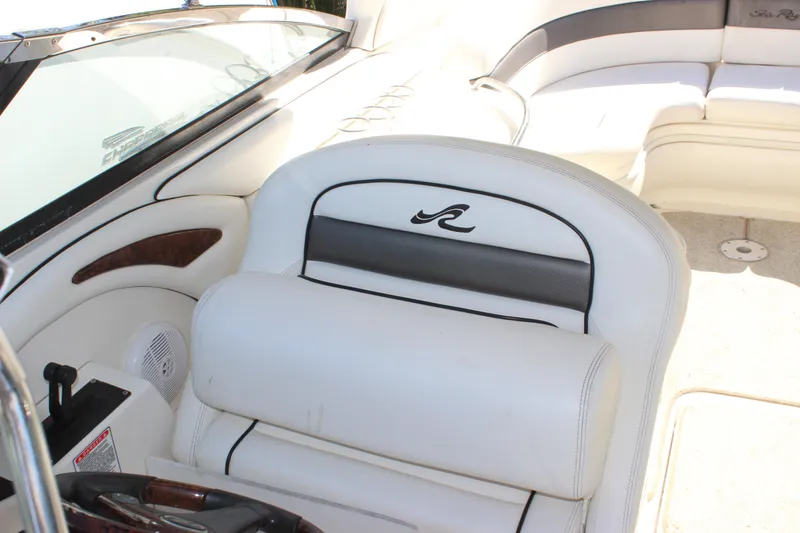 Slide: The Image of 2005 Sea Ray 290 Sundeck interior with white seating and steering area. - 28