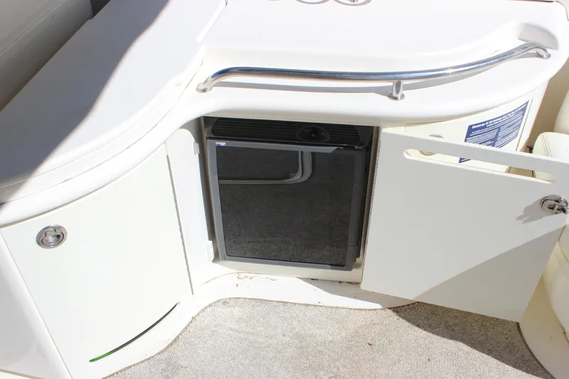 Slide: The Image of 2005 Sea Ray 290 Sundeck boat interior with mini fridge and storage compartment. - 30