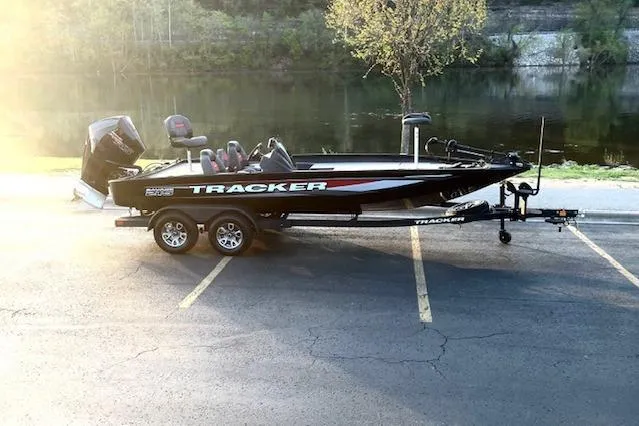 Slide: The Image of 2025 Tracker Savage 215 boat on trailer by a serene lake. - 108