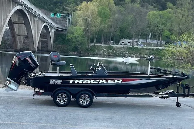 Slide: The Image of 2025 Tracker Savage 215 boat on trailer by river and bridge. - 110