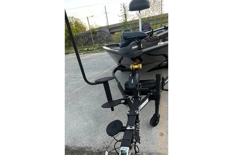 Slide: The Image of 2025 Tracker Savage 215 boat on trailer with Minn Kota motor in parking lot. - 114